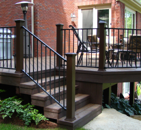 A large deck with black metal railing, built by Cedar Works deck builders