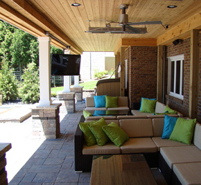 A cozy porch with deck furniture and hardscape, designed and built by Cedar Works.